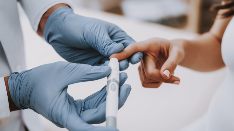 Blogcover Diabetes Person, die sich an Fingerkuppe Blut abnehmen lässt